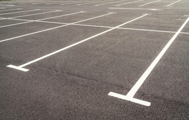 Fresh paint on asphalt marking out car parking spaces over a large area.© Christina Iberl